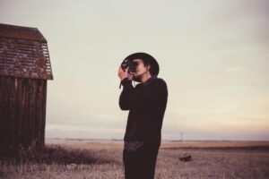 A man using a camera in a field symbolizes the search for new interests and hobbies in sobriety.
