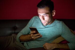 A man using his phone before going to an addiction treatment center Idaho