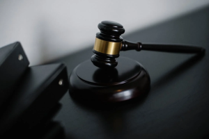 A close-up shot of a wooden gavel resting on a judge's block.