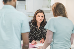 An image of a woman talking to a couple
