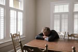 An image of a person sitting on a brown wooden chair