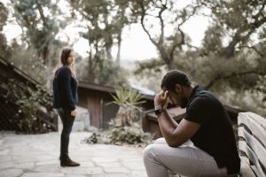 Woman looking toward a stressed man seated beside her.
