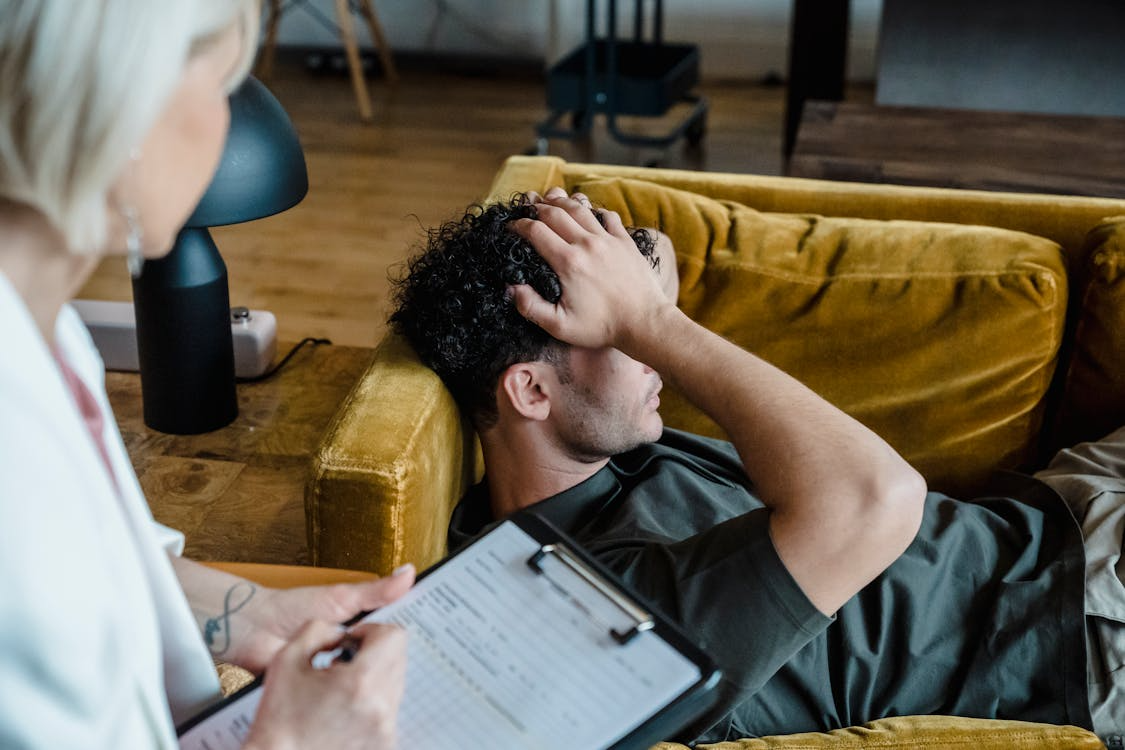 Male client receiving one-on-one counseling in a trauma-informed inpatient sexual addiction treatment program.