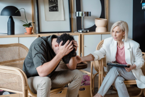 Male client receiving one-on-one counseling from a therapist in a private office.