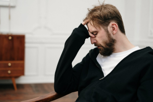 a man sitting in a chair, stressed out