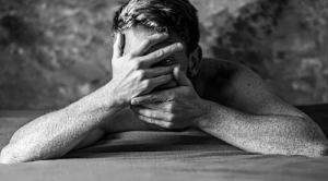 A man covering his face with both hands