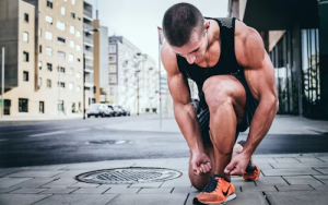 A man in jogging gear tying his shoe