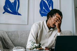 This photo shows a man holding his head.